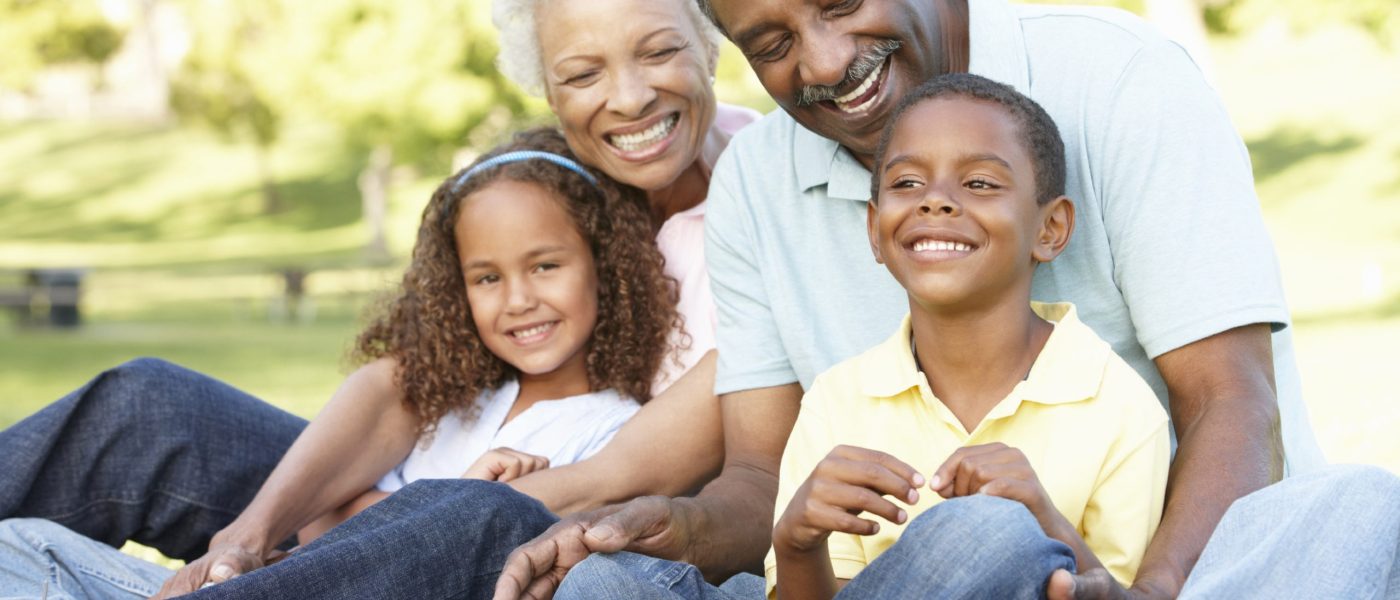 African American Grandparents With Grandchildren Relaxing In Park